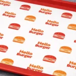 Custom printed tray liner paper on a red food tray – custom printed packaging by Texas Food Pack